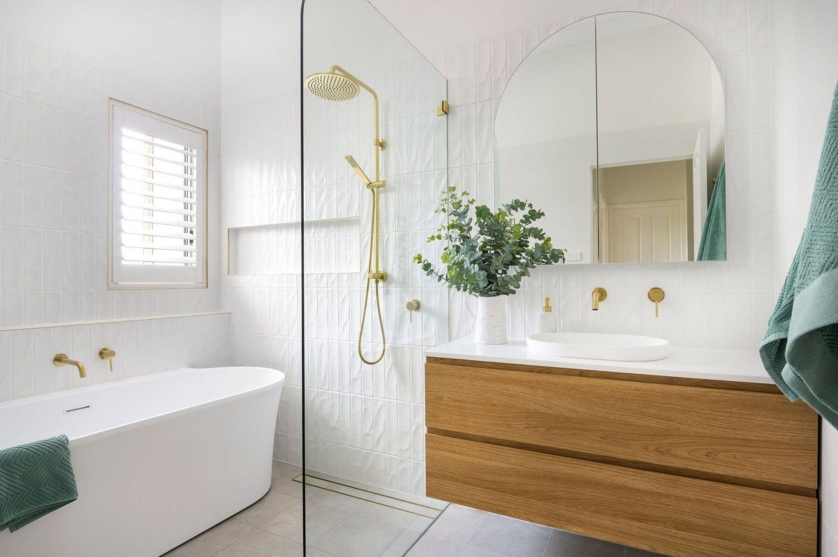 White tile bathroom with brass fixtures
